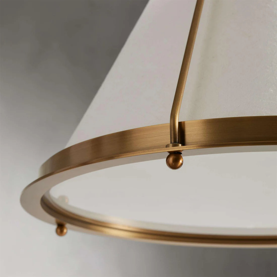 Melton Pendant Light – a striking blend of smooth brass and textured linen fabric, featuring industrial-inspired brass arms and flared shades, elegantly accented with brass detailing at the base.