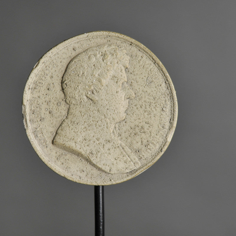 19th-Century Stucco Collector's Medallions – artist-crafted commemorative pieces, displayed on matte black metal stands, honoring past exhibitions and events.