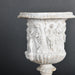 19th-Century Classical-Style Medici Vase – ceramic replica with a Greek scene, inspired by temple sculptures, featuring an aged patina finish.